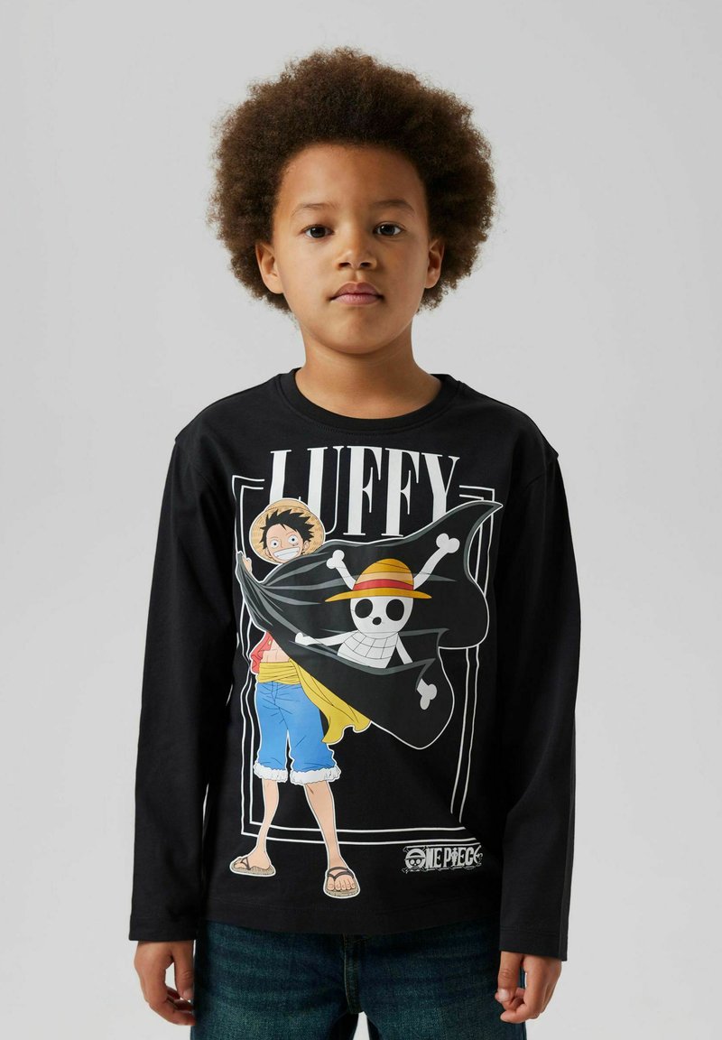 Schwarzes Langarmshirt mit einem grafischen Druck eines Charakters mit einem Strohhut und einem Totenkopf, kombiniert mit blauen Jeans und einem lässigen Schnitt.