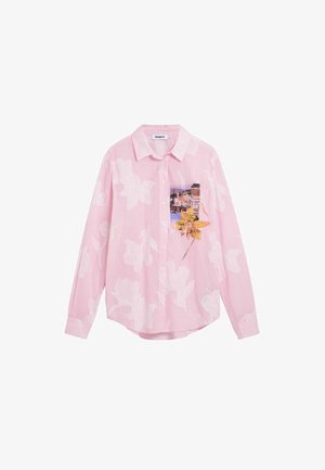Camisa rosa abotonada con patrones florales blancos y un bolsillo que muestra un pueblo costero y una gran flor amarilla.