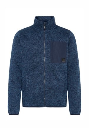 Navy blue fleece jacket with a zip-up front, high collar, textured pattern, and a contrasting pocket on the left chest with logo detail.