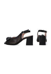 Schwarze Slingback-Pumps mit einem durchbrochene Netzdesign, runder Zehenform und blockartigem Absatz. Akzentuiert mit einem großen, runden Detail an der Vorderseite.