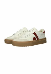 White low-top sneakers with brown gum soles, red suede side stripe and circle detail, and white laces.