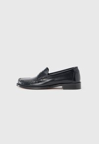 Black leather loafer featuring a rounded toe, decorative stitching, and a low block heel. Smooth texture, minimal accents.