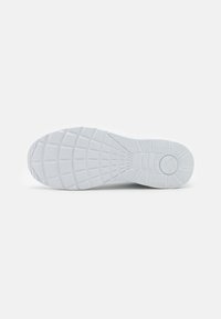 Witte sneakerzool met een gestructureerd rubberpatroon, met een gevormd logo en een dik profielontwerp voor verbeterde grip.