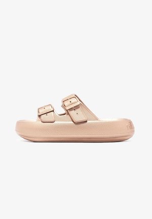 Sandalias de color melocotón con una superficie texturizada, dos correas ajustables y una suela elevada. Presentan un diseño minimalista y sin acentos adicionales.