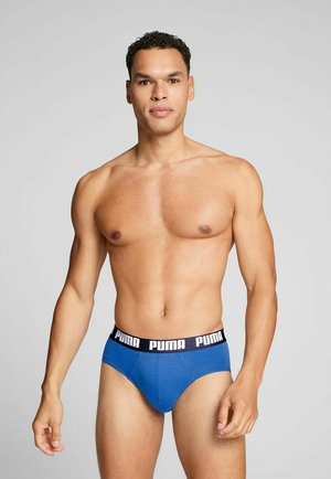 Blaue Slips aus dehnbarem Stoff mit einem schwarzen Bund, der das Puma-Logo trägt. Schlanker Schnitt mit minimalen Nähten.