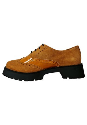 Zapato oxford de ante marrón con un acento naranja brillante, detalles perforados, cordones negros y una suela de goma negra gruesa y texturizada.