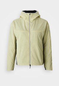 Chaqueta con capucha de color amarillo claro, con cremallera frontal, textura suave y paneles laterales de malla. Presenta un alto cuello y puños elásticos.