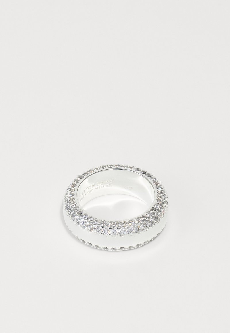 Silver ring med en slät ring, prydd med en rad klara kristaller längs den övre kanten, glansig finish och texturerad detaljering på sidorna.