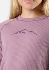Vaalean violetti pitkähihainen paita, jossa on ribbitekstuuri. Rintakappaleessa tumman violetin värinen vuorikuvio. Saumojen yksityiskohdat näkyvissä.