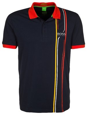 Granatowa koszulka polo z czerwonym kołnierzem i wykończeniem rękawów, pionowymi czerwonymi, żółtymi i białymi paskami oraz białym logo "BOSS" na piersi.
