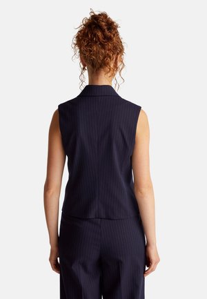 Blazer senza maniche blu navy con righe verticali, dotato di colletto a rever e vestibilità sagomata, realizzato con un tessuto liscio e dettagli minimi.