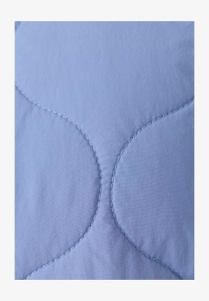 Tissu matelassé bleu clair présentant un motif de couture festonné. Texture lisse avec un léger éclat, mettant en valeur les courbes et les coutures.