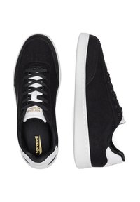 Adida�și negri tip low-top cu tălpi și accente albe la călcâi, șireturi negre, logo-ul vizibil al brandului pe branț și pe limbă, prezentati din vederi superioare și laterale.