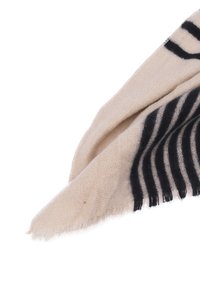 Sciarpa beige realizzata in tessuto testurizzato con strisce scure. I bordi sono sfrangiati, evidenziando una finitura informale e una caduta morbida.