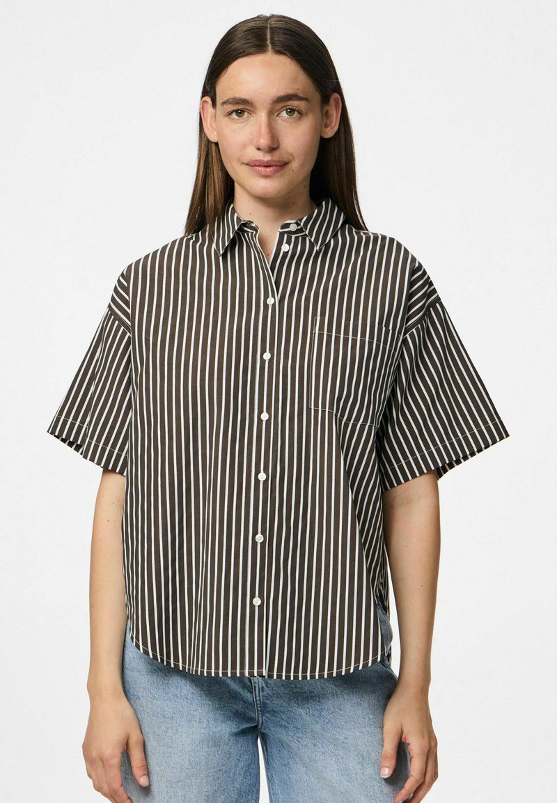 Camicia corta a maniche con righe marroni e bianche, colletto, chiusura con bottoni e tasca sul petto; realizzata in tessuto leggero e traspirante.