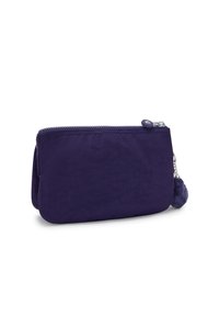 Pequeña bolsa rectangular morada oscura con cremallera y una pestaña de tela, adornada con un llavero de pompones esponjosos, sobre un fondo blanco.