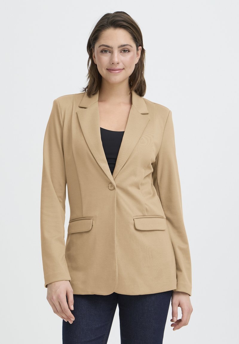 Blazer beige con chiusura a un bottone, rever a punte e due tasche frontali, realizzato in tessuto morbido, design aderente, maniche lunghe.