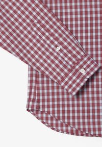 Camisa de cuadros vichy en rojo y blanco, con mangas largas, puños abotonados, dobladillo curvado y un bolsillo en el lado izquierdo. Confeccionada en tela de algodón.