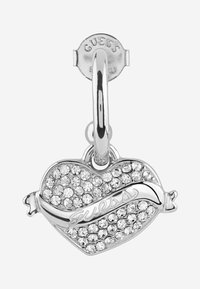 Srebrny wisiorek w kształcie serca z małymi przezroczystymi kryształkami, z napisem 'Guess' w formie wstążki na środku.