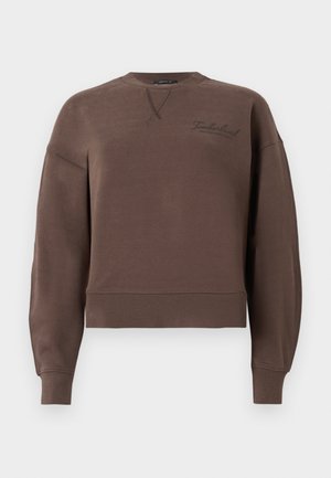 Brun cropped sweatshirt laget av mykt materiale, med rund hals, ribbede mansjetter og en liten brodert logo på forsiden.