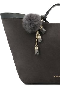 Geantă tote din suede gri, cu un detaliu de piele neagră lucioasă, având un pompon din blană artificială gri și un lanț de ton auriu cu detalii decorative.