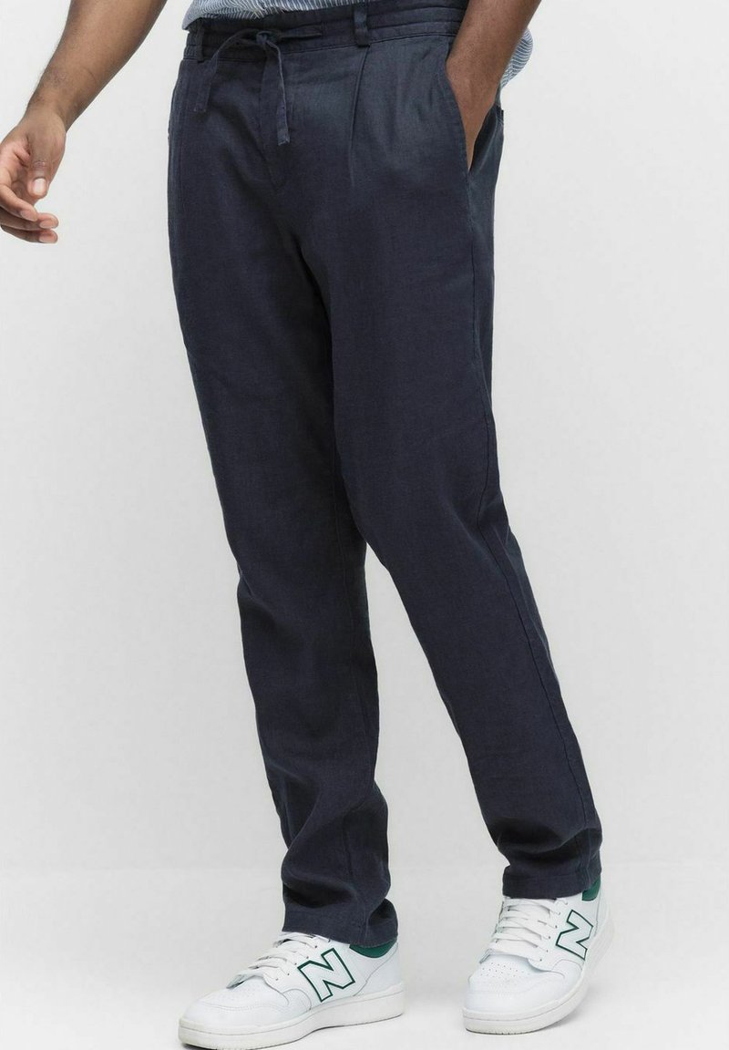 Marineblauwe broek met een relaxed fit, gemaakt van lichtgewicht stof. Heeft een elastische tailleband met koord, zijzakken en een taps toelopende pijp.