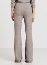 Pantaloni beige a coste con design a gamba svasata. Tessuto morbido, vita alta e bordi sfrangiati all'orlo per un dettaglio aggiuntivo.