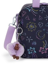 Borsa nera con motivi multicolori. Caratterizzata da una tracolla viola e un portachiavi con una figura di gorilla viola peluccioso e un volto marrone.