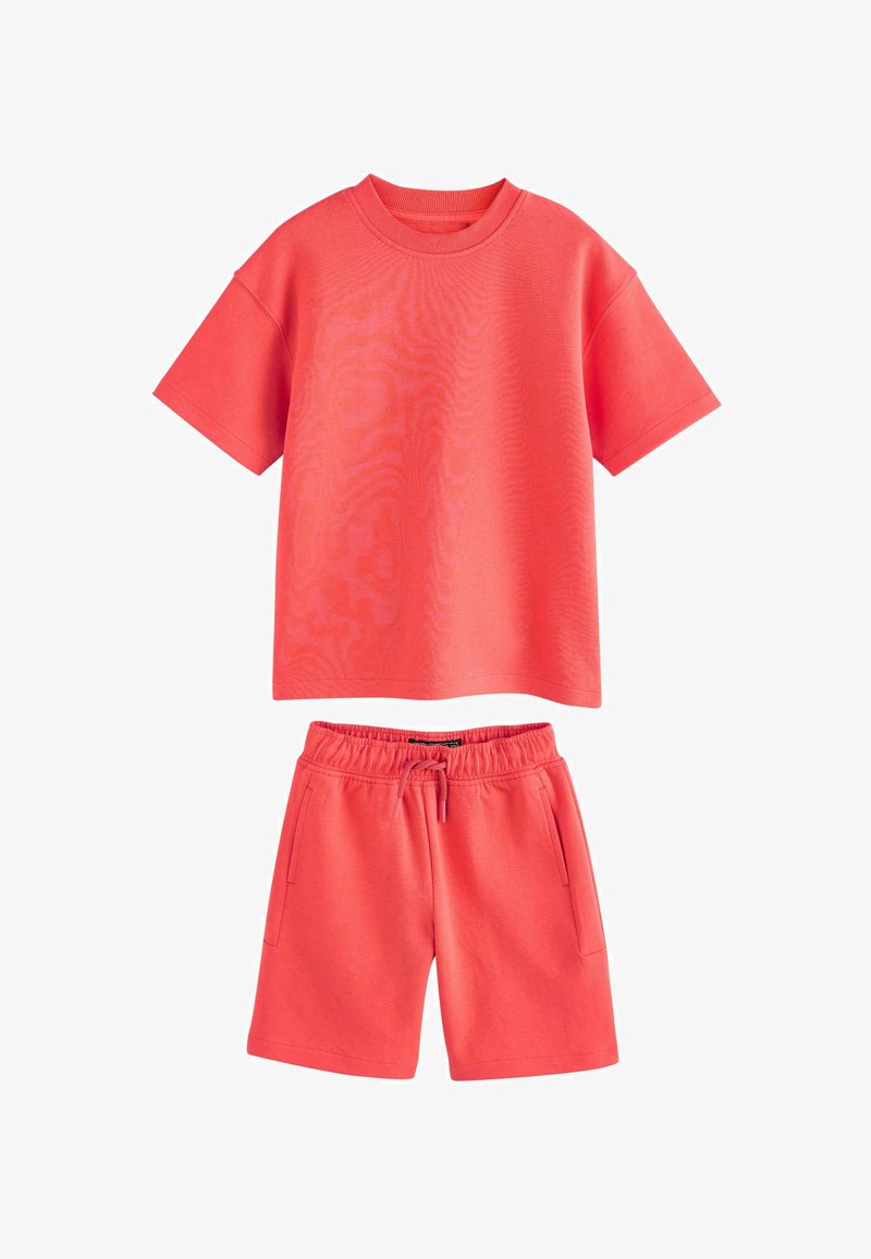 Ensemble décontracté couleur corail avec t-shirt à manches courtes et col rond, et short à taille élastique avec cordon de serrage et poches latérales.