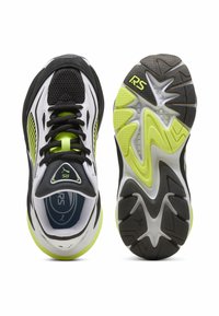 Schwarz-weiße Sportschuhe mit neon-grünen Akzenten, die ein Obermaterial aus Mesh, eine strukturierte Sohle und ein markantes Zickzackmuster an der Außensohle aufweisen.