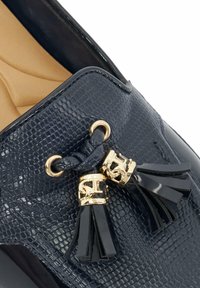 Marine loafers met een gestructureerde, reptielachtige bovenkant, voorzien van gouden hardware en zwarte lederen kwastjes. Rond uiteinde en gevoerde binnenkant.