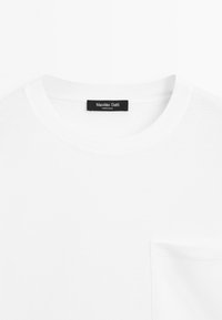 Weißes Baumwoll-T-Shirt mit Rundhalsausschnitt und einer linken Brusttasche. Besitzt ein schwarzes Etikett mit dem Text "Massimo Dutti" am Hals.