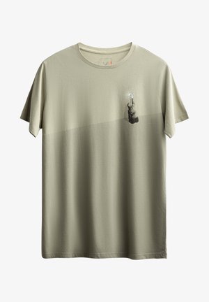 Olijfgroene t-shirt van zachte stof, met een horizontale lichtere band en een afbeelding van een figuur die een object vasthoudt tegen een gestructureerde achtergrond.