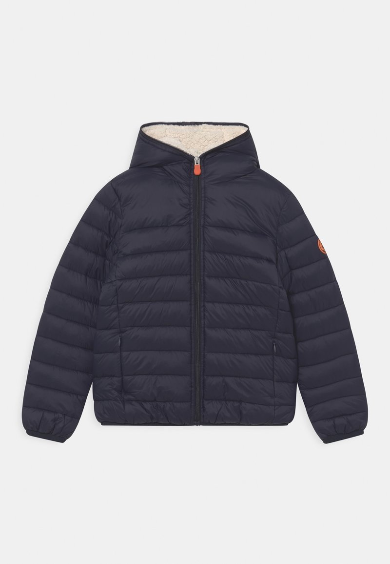 Marineblå quiltet pufferjakke med hætte, frontlynlås og cremefarvet foer. Inkluderer elastiske manchetter og en orange lynlåsdriver.
