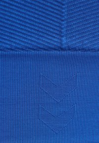 Blauwe sportstof heeft een gestructureerd ribontwerp, dat overgaat in een glad gedeelte met reliëf chevronpatronen.