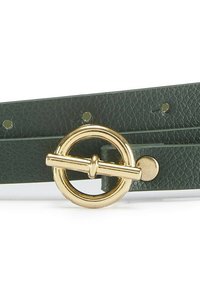 Zaļa ādas josta ar tekstūras apdari, apaļu zelta toņa sprādzi un regulējamu mēli ar vienādiem caurumiem.