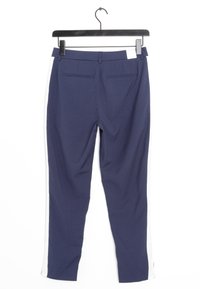 Námořnické kalhoty s bílými bočními pruhy, vyrobené z měkké látky. Obsahují dvě zadní kapsy, slim fit střih a jsou zavěšeny na černém ramínku.