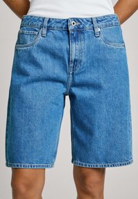 Tupeeritud sinised denim lühikesed püksid sirge lõikega, viie taskuga, vööaugud ja nähtavad õmbluseDetails. Lõpeb just põlve kohal.