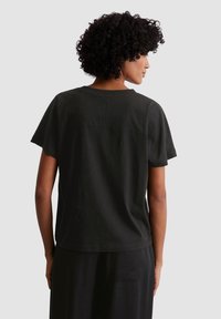 Zwarte katoenen t-shirt met korte mouwen, een ronde hals en een ontspannen pasvorm, met een naadloos ontwerp van de rugpand.