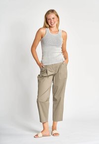 Graues geripptes Tanktop kombiniert mit hellbeigen, plissierten Hosen und beigen Sandalen, mit lässiger Passform und Seitentaschen.