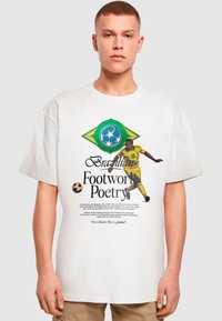 Hvid t-shirt med et grafisk design af det brasilianske flag, tekst der lyder "Brazilian Footwork Poetry" og en atlet i en gul trøje.