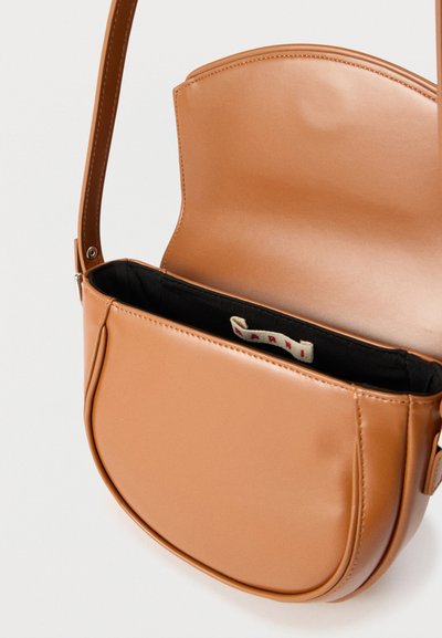 Τσάντα χιαστί από ταμπά δέρμα με ανοιχτό καπάκι που αποκαλύπτει μαύρο υφασμάτινο εσωτερικό και μικρή λευκή ετικέτα επωνυμίας στο εσωτερικό.