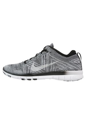 Chaussure de sport tricotée gris et noir à coupe basse avec semelle blanche flexible et lacets noirs, vue de profil.