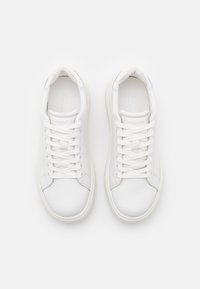 Vita sneakers med en slät läderovandel, platta snören, rund tå och en minimalistisk design. Subtil branding på tungan.