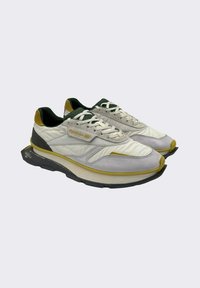 Sneaker bianchi e grigi con tomaia texturizzata, accenti verdi e gialli, lacci piatti e suola nera chunky per maggiore altezza e supporto.