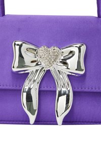 Borsa a tracolla in raso viola con un accent metallic silver a forma di fiocco, con un centro a forma di cuore decorato con strass. Design semplice e elegante.