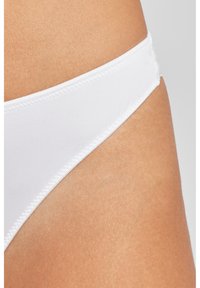 Weiße Bikini-Unterteile aus glattem Stoff, mit einem tief sitzenden Schnitt und dünnem Taillenbund, die saubere Nähte am Rand aufweisen.