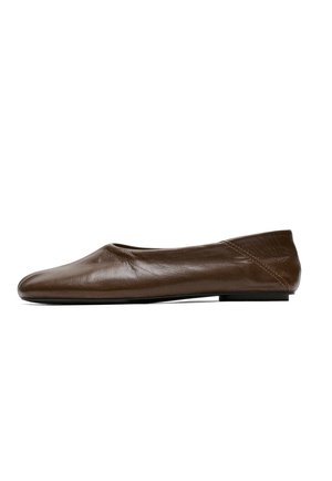 Chaussure plate en cuir marron avec un bout rond et des coutures minimales, vue de profil sur fond blanc.