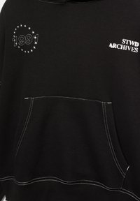Black sweatshirt with white stitching, featuring an embroidered "1991" surrounded by stars and "STWD ARCHIVES" text on the front. Front pocket included.