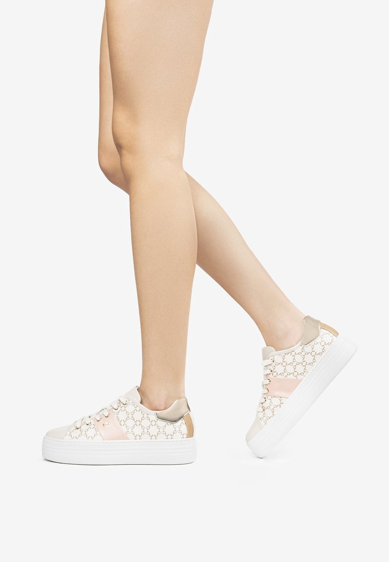 Baskets à plateforme blanches avec un motif texturé en beige et rose clair, dotées d'un accent lisse en tan au niveau du talon et de lacets clairs.